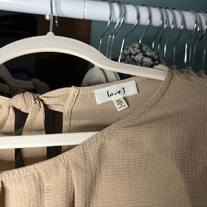 Cream breezy blouse by Love J with two bows in the back.
